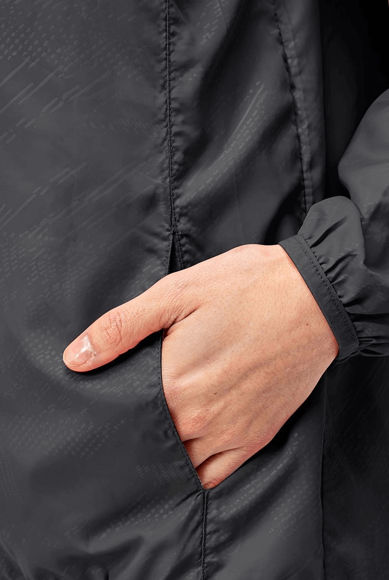 Close-up of a hand in the pocket of a black waterproof women's windbreaker with zipper for running in all weather, model SF0136.